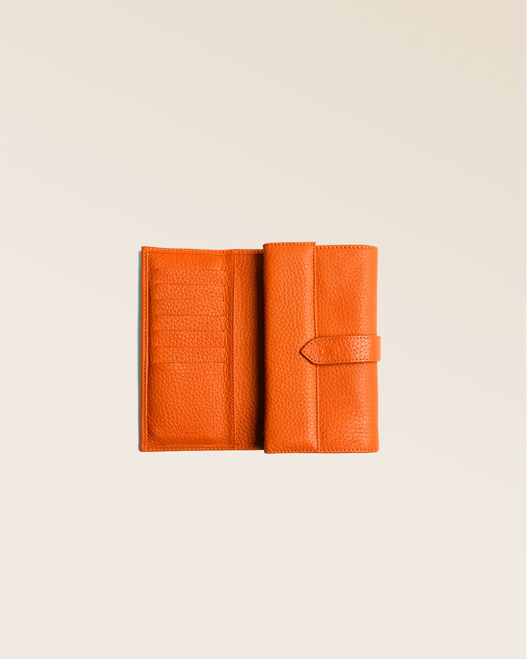 Notre porte-monnaie Adèle en cuir façon vigogne orange vu ouvert en studio.