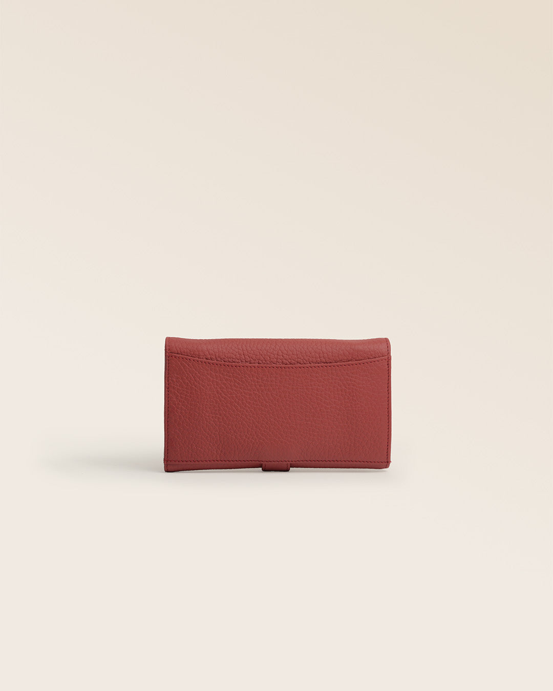 Notre porte-monnaie Adèle Renouard en cuir façon vigogne terracotta, vu de dos en studio.