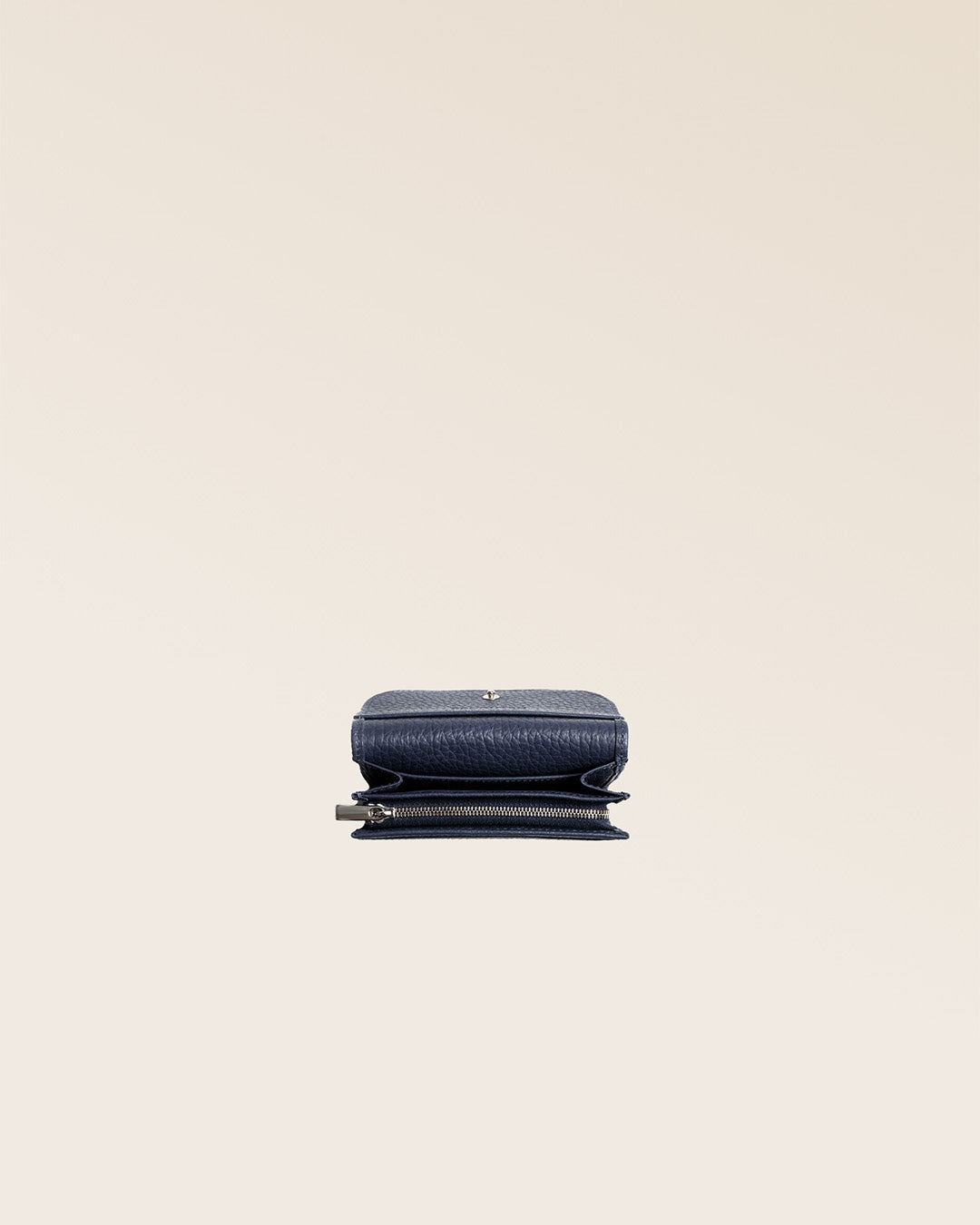 Our Alma wallet in navy blue vicuña-style leather, seen from above in the studio.