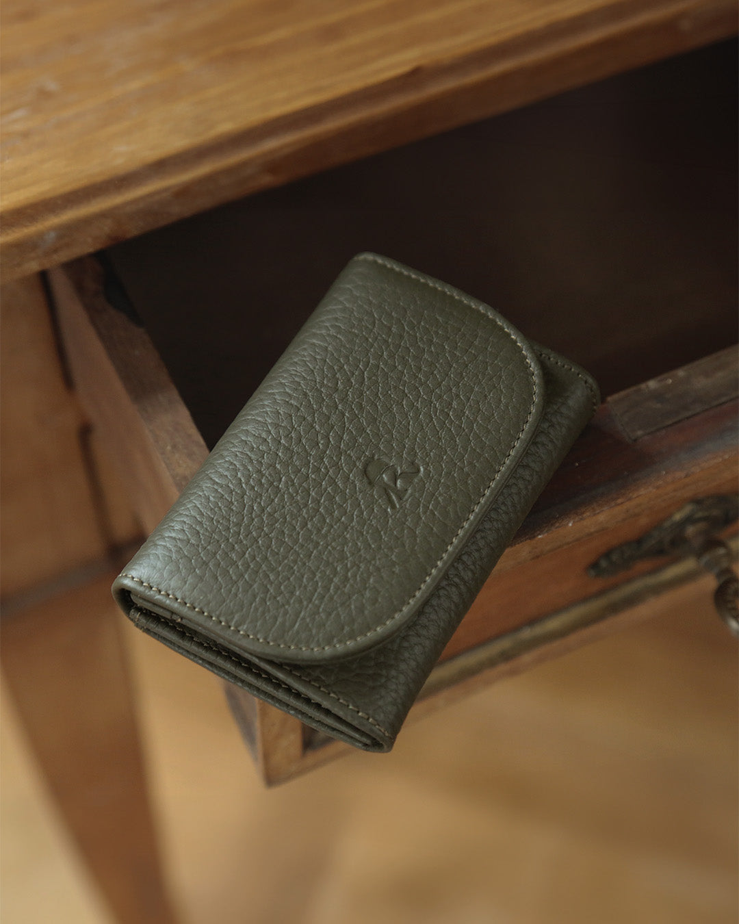 Our Alma Renouard wallet in khaki vicuña-style leather, seen in ambiance.
