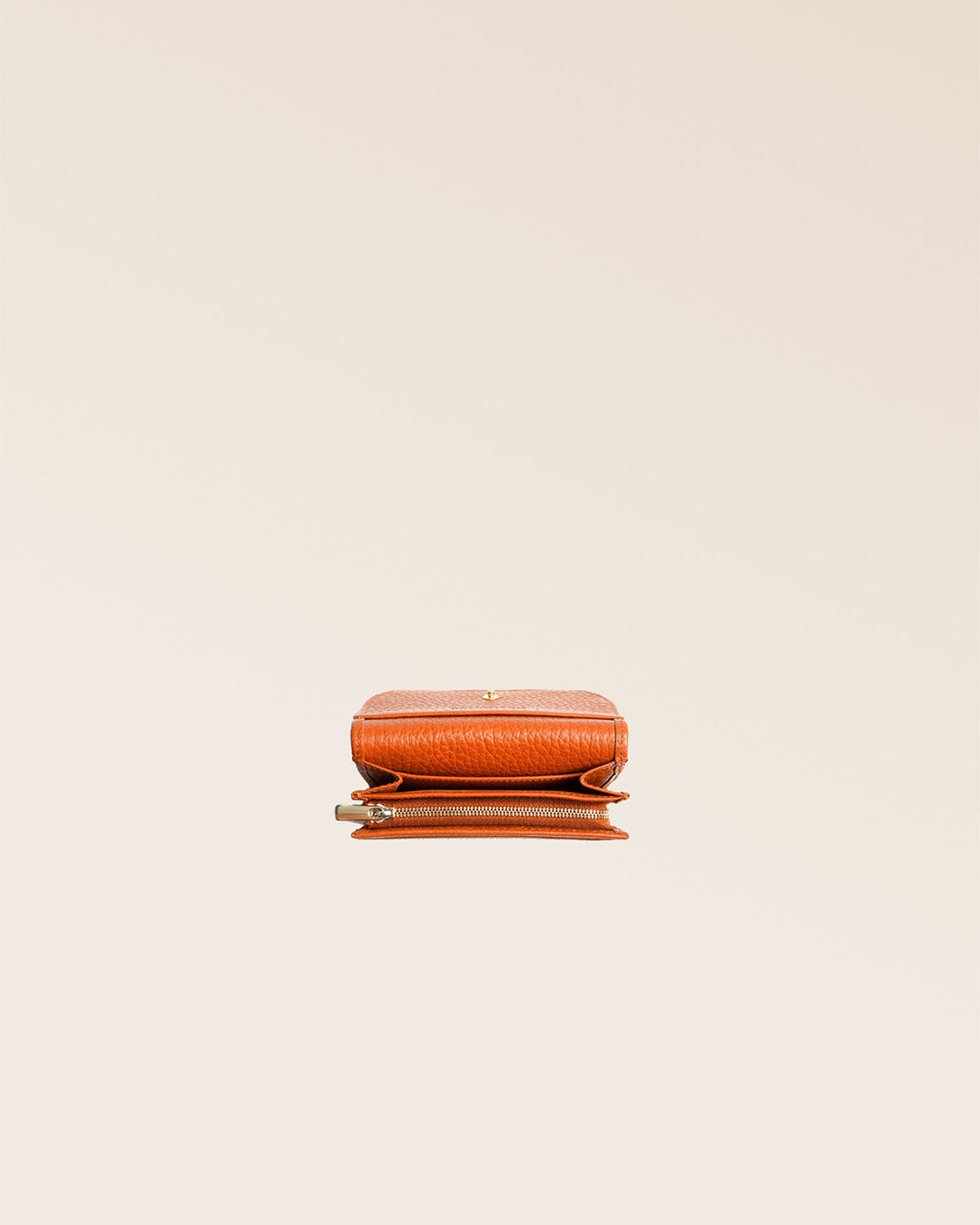 Notre porte-monnaie Alma en cuir façon vigogne orange vu ouvert en studio.