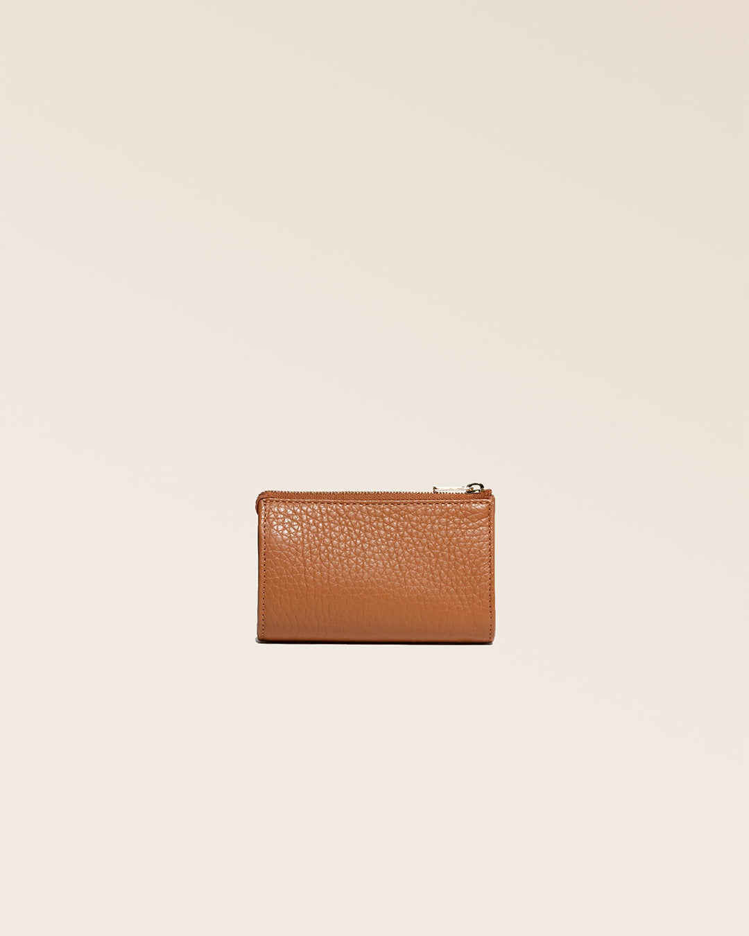 Notre porte-monnaie Birdy en cuir façon vigogne fauve vu de dos en studio.