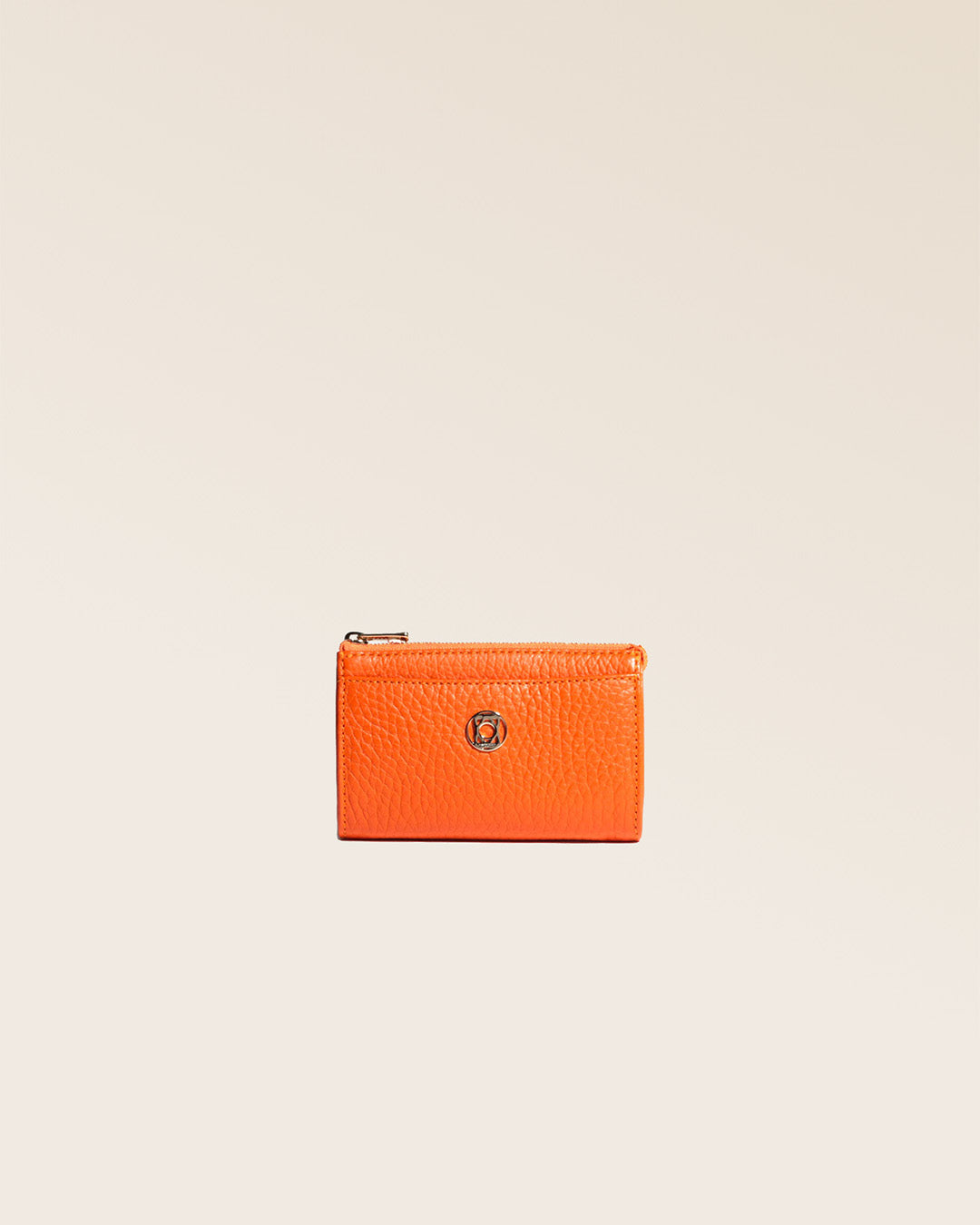 Notre porte-monnaie Birdy en cuir façon vigogne orange vu de face en studio.