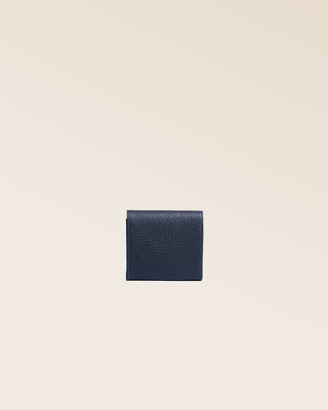 Notre porte-monnaie Castel en cuir façon vigogne bleu marine vu de dos en studio.