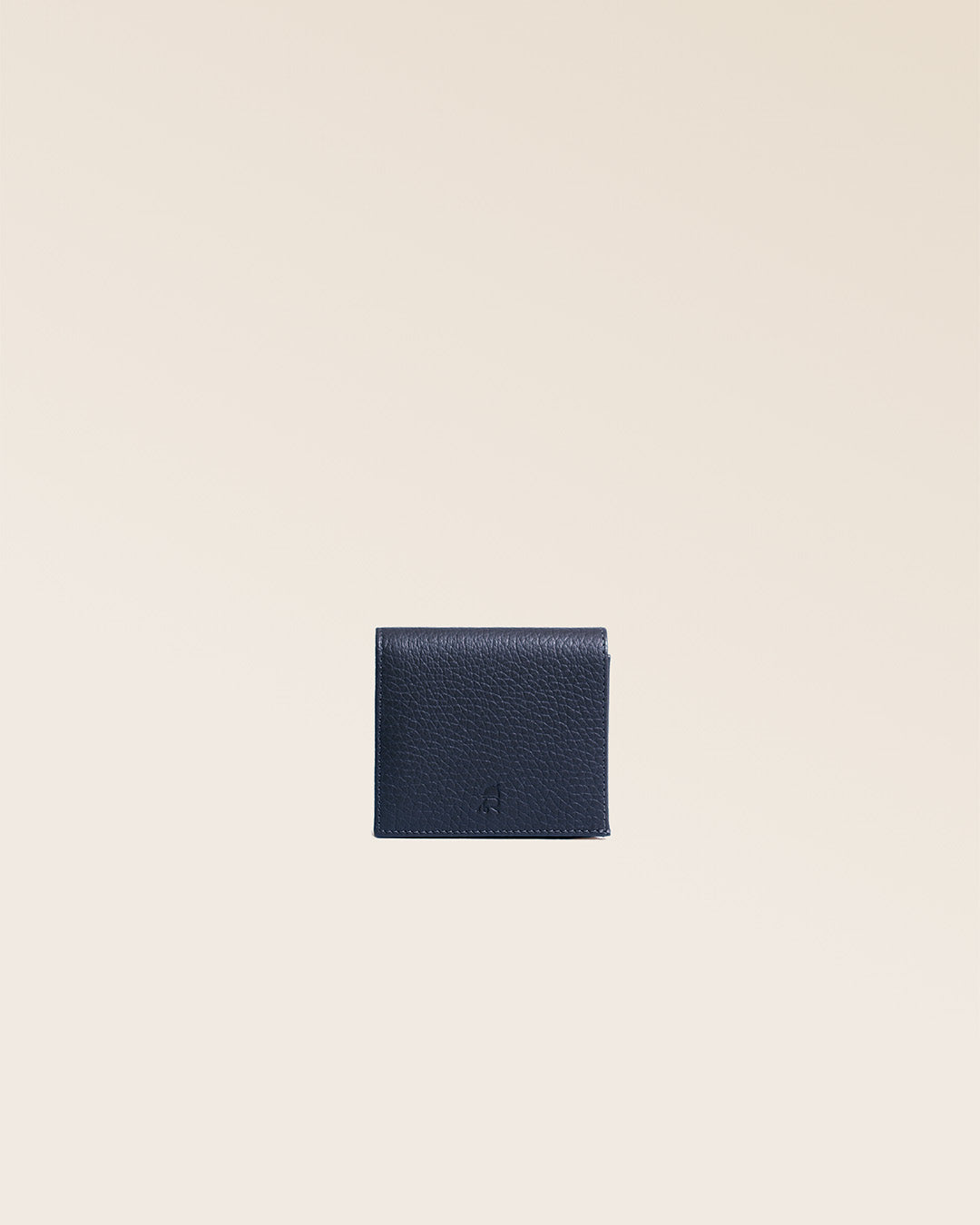 Notre porte-monnaie Castel en cuir façon vigogne bleu marine vu de face en studio.