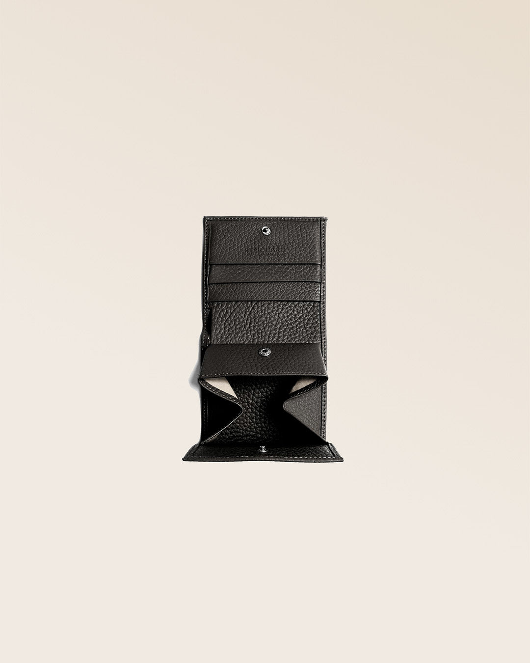 Notre porte-monnaie Castel en cuir façon vigogne noir vu ouvert en studio.