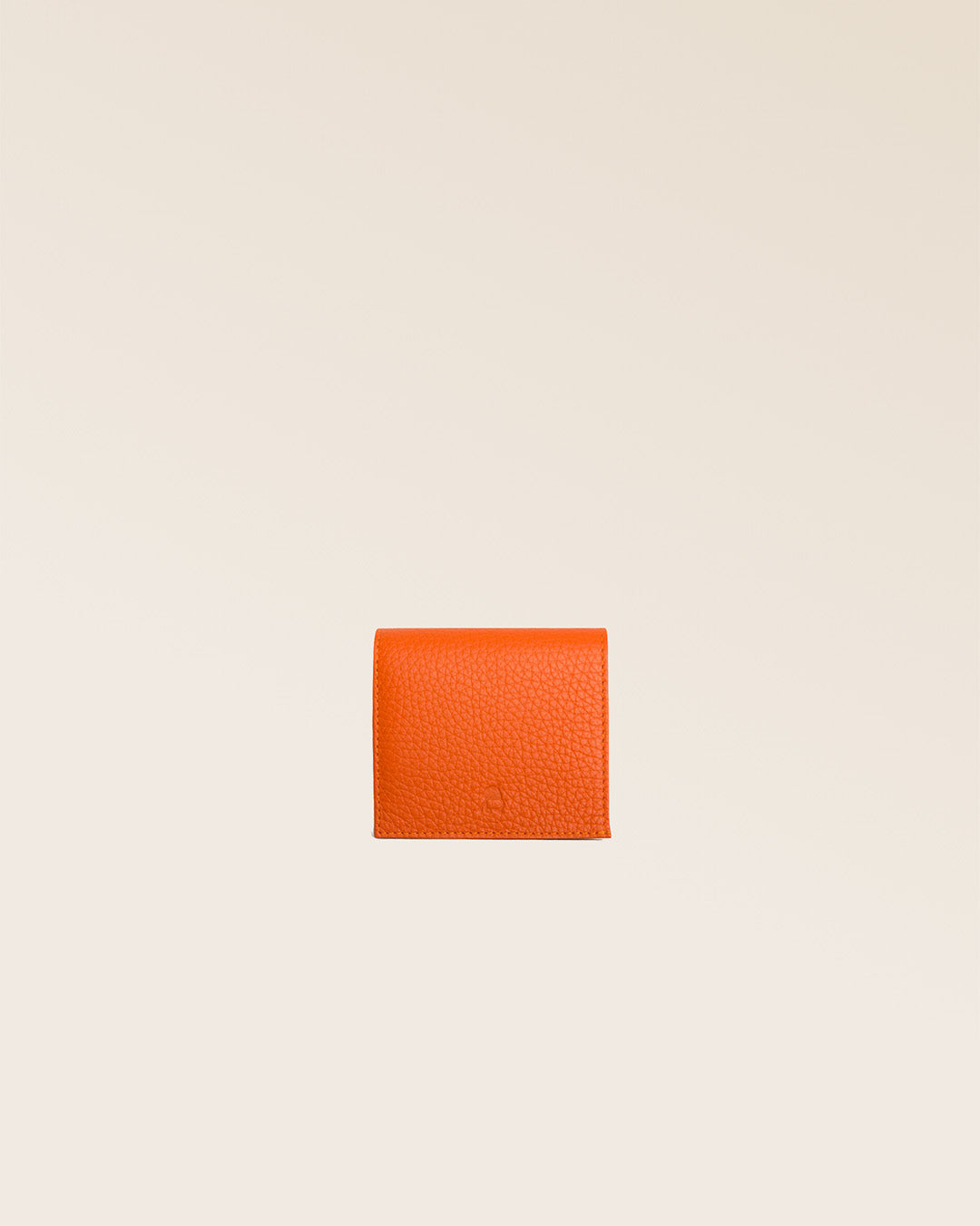 Notre porte-monnaie Castel en cuir façon vigogne orange vu de face en studio.