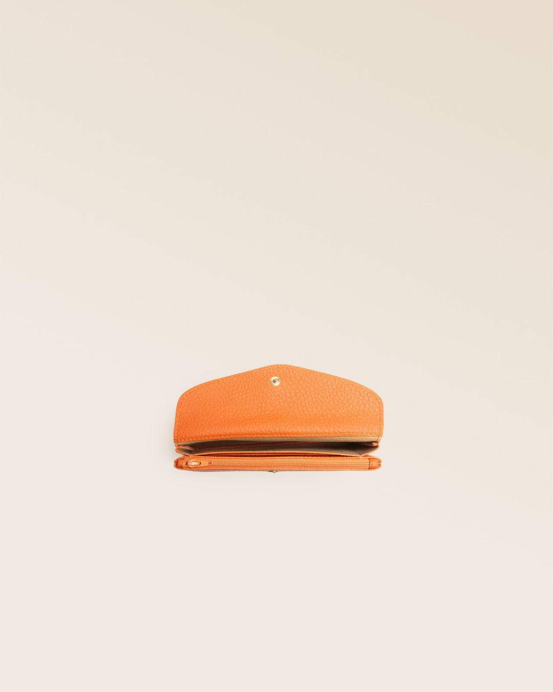 Notre porte-monnaie Lilou en cuir façon vigogne orange vu du dessus en studio.