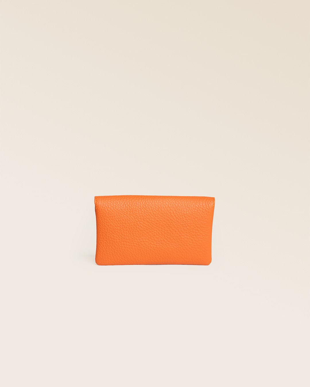 Notre porte-monnaie Lilou en cuir façon vigogne orange vu de dos en studio.