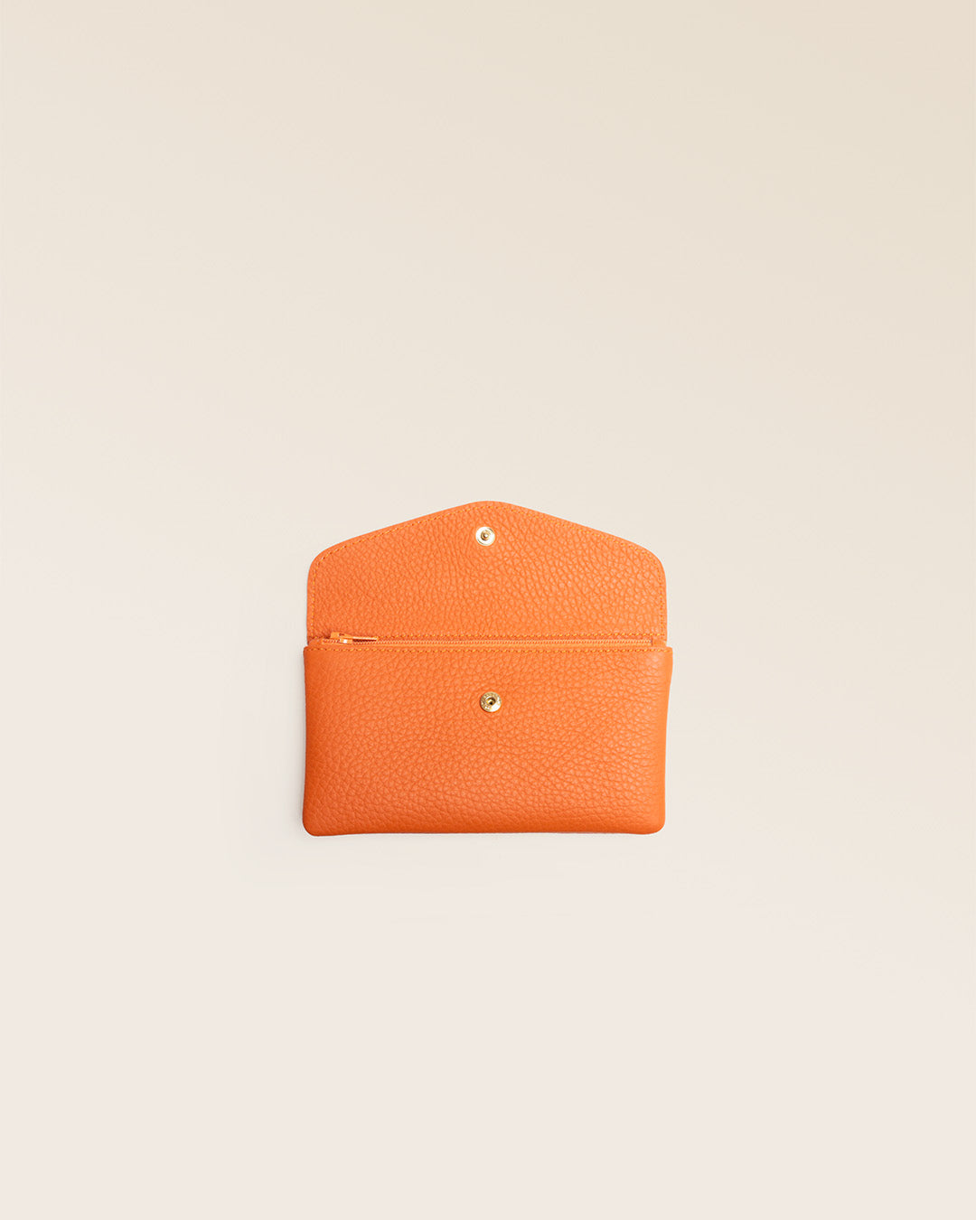 Notre porte-monnaie Lilou en cuir façon vigogne orange vu de face ouvert en studio.