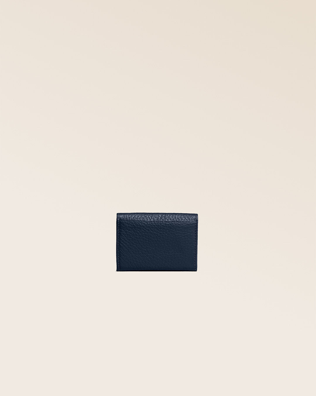 Our Mixte wallet in navy blue vicuña-style leather, seen from the back in the studio.