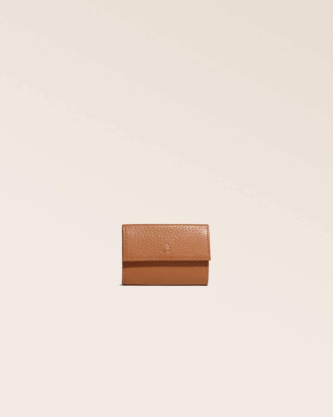 Notre porte-monnaie Mixte en cuir façon vigogne fauve vu de face en studio.