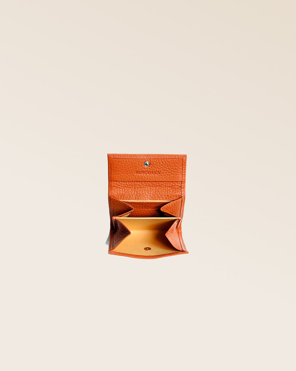 Notre porte-monnaie Mixte en cuir façon vigogne orange vu ouvert en studio.