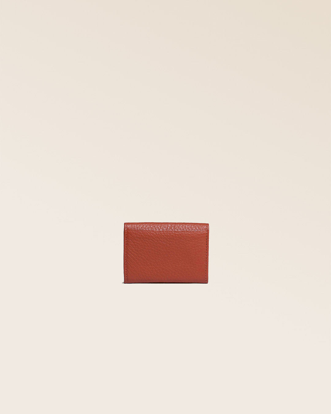 Notre porte-monnaie Mixte en cuir façon vigogne terracotta vu de dos en studio.
