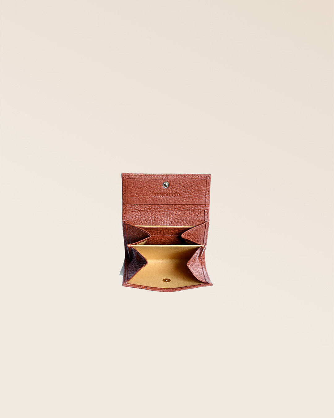 Notre porte-monnaie Mixte en cuir façon vigogne terracotta vu ouvert en studio.