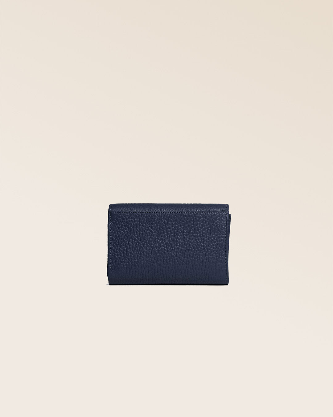 Our Opale wallet in navy blue vicuña leather seen from the back in the studio.