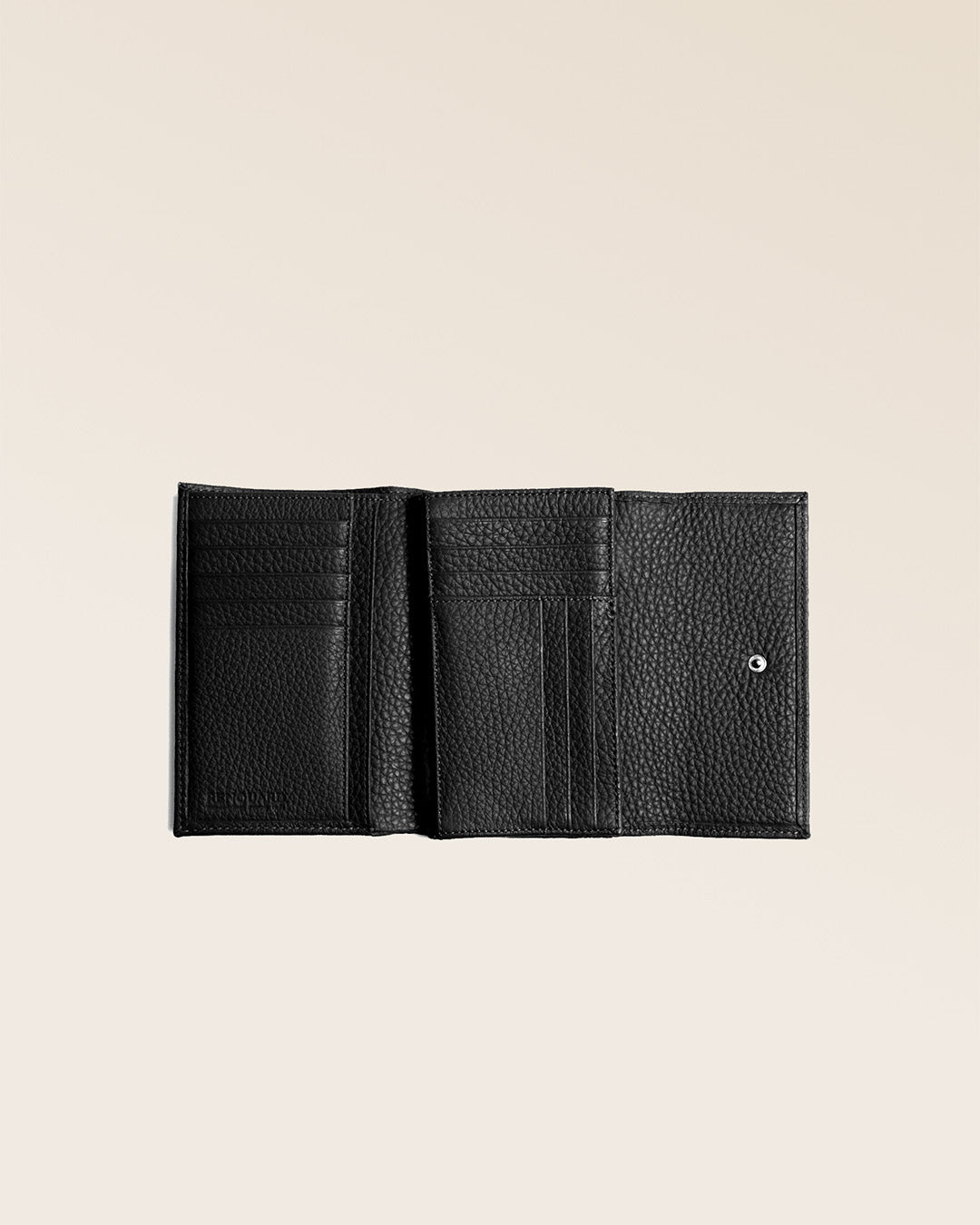 Our Opale purse in black vicuña-style leather seen open in the studio.