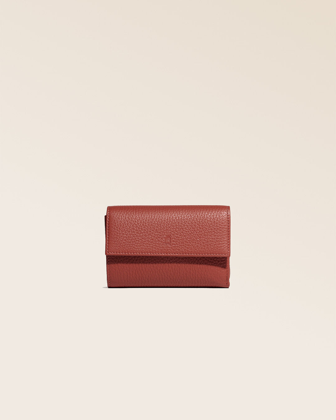 Notre porte-monnaie Opale en cuir façon vigogne terracotta vu de face en studio.