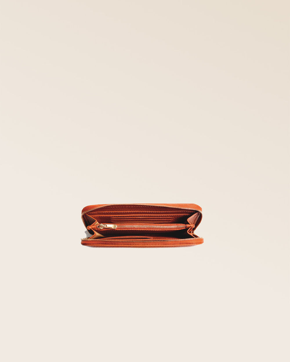 Notre porte-monnaie Samba en cuir façon vigogne orange vu du dessus en studio.