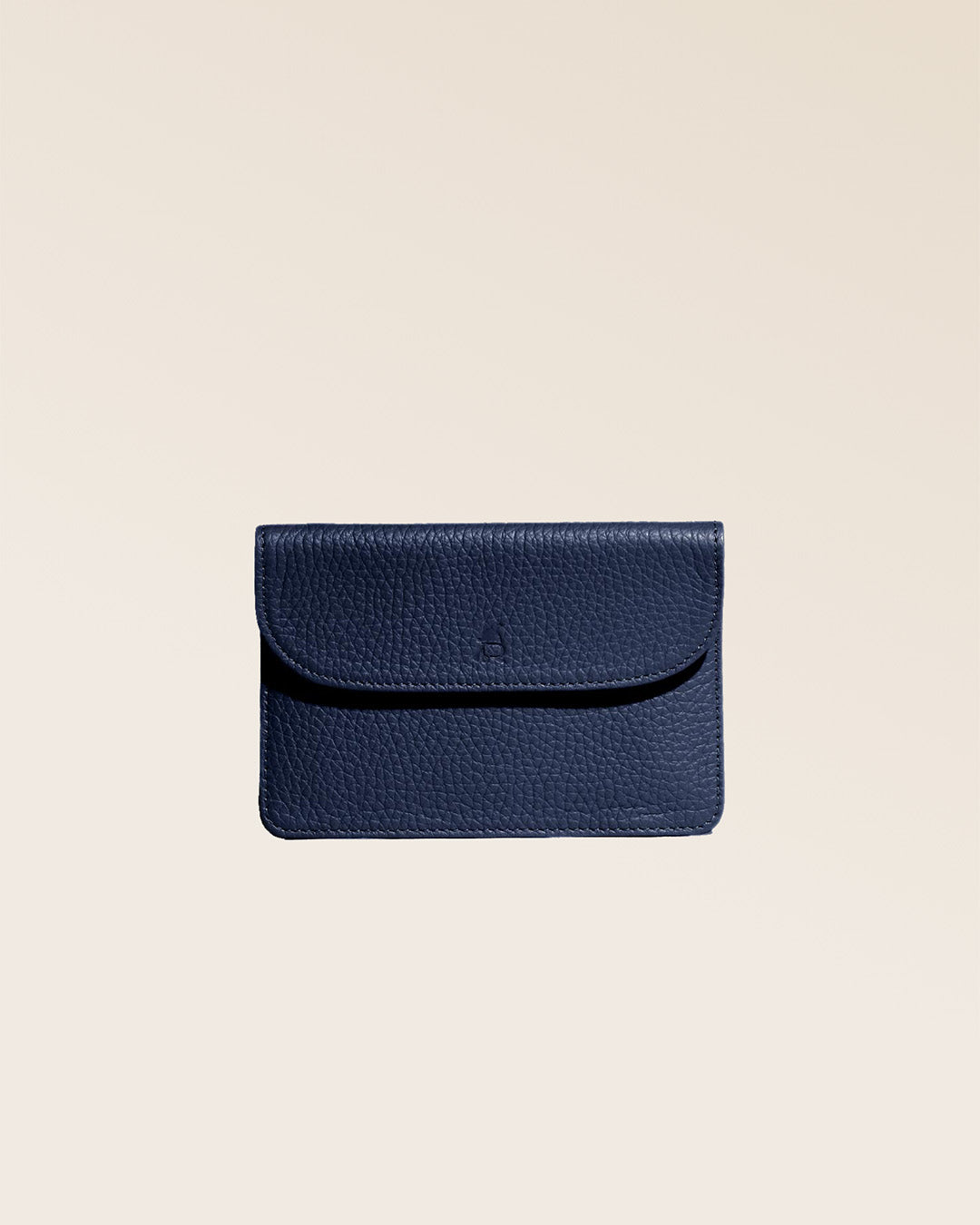 Notre porte-papiers Aurore en cuir façon vigogne bleu marine vu de face fermé en studio.