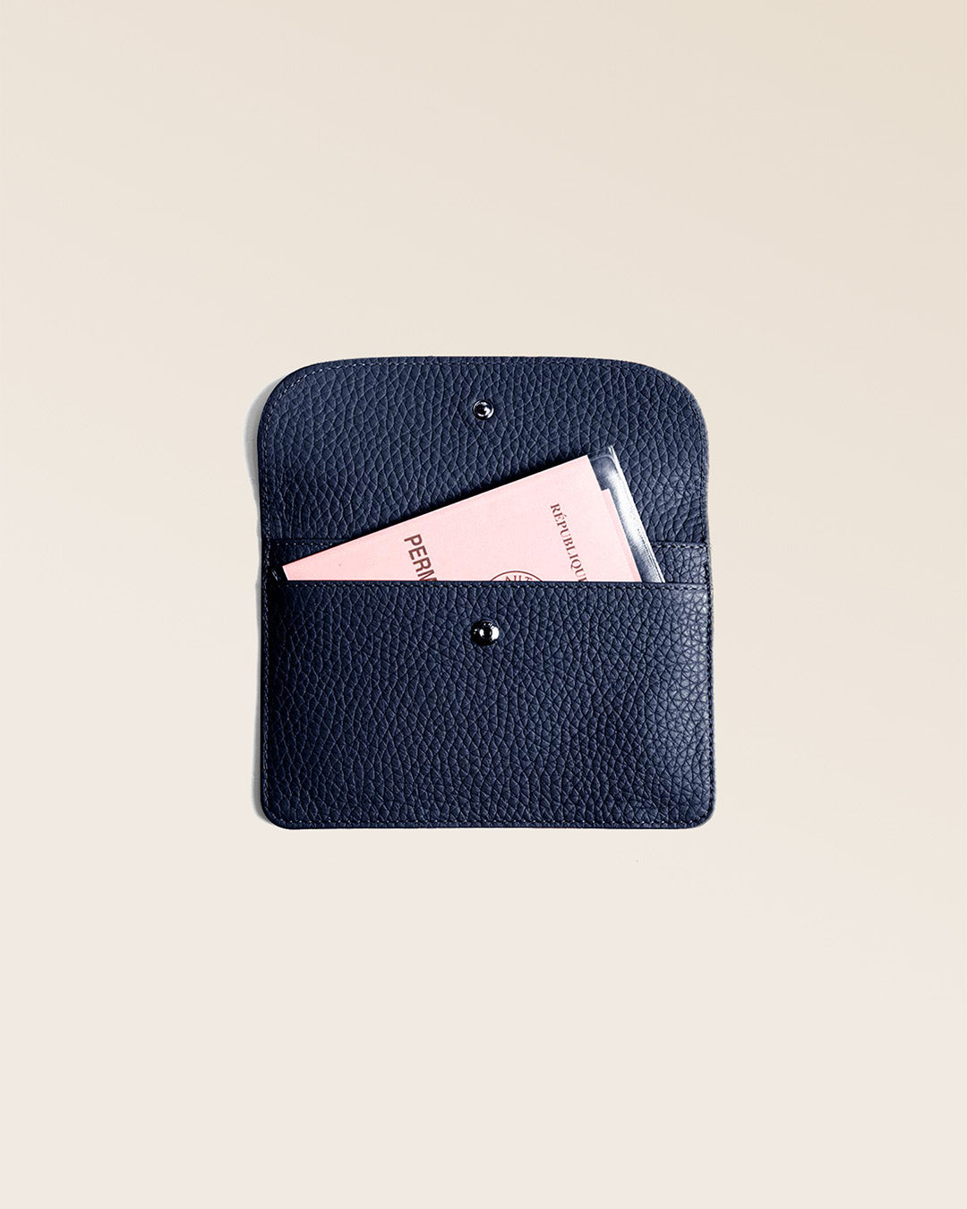 Notre porte-papiers Aurore en cuir façon vigogne bleu marine vu de face ouvert en studio.