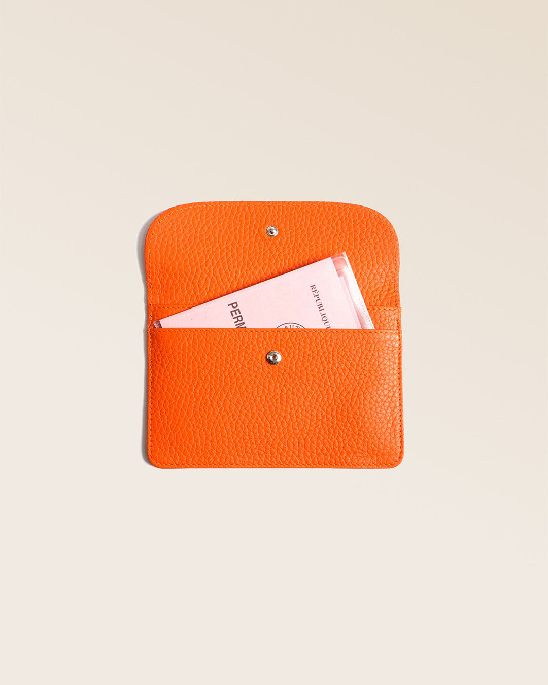 Notre porte-papiers Aurore en cuir façon vigogne orange vu ouvert en studio.