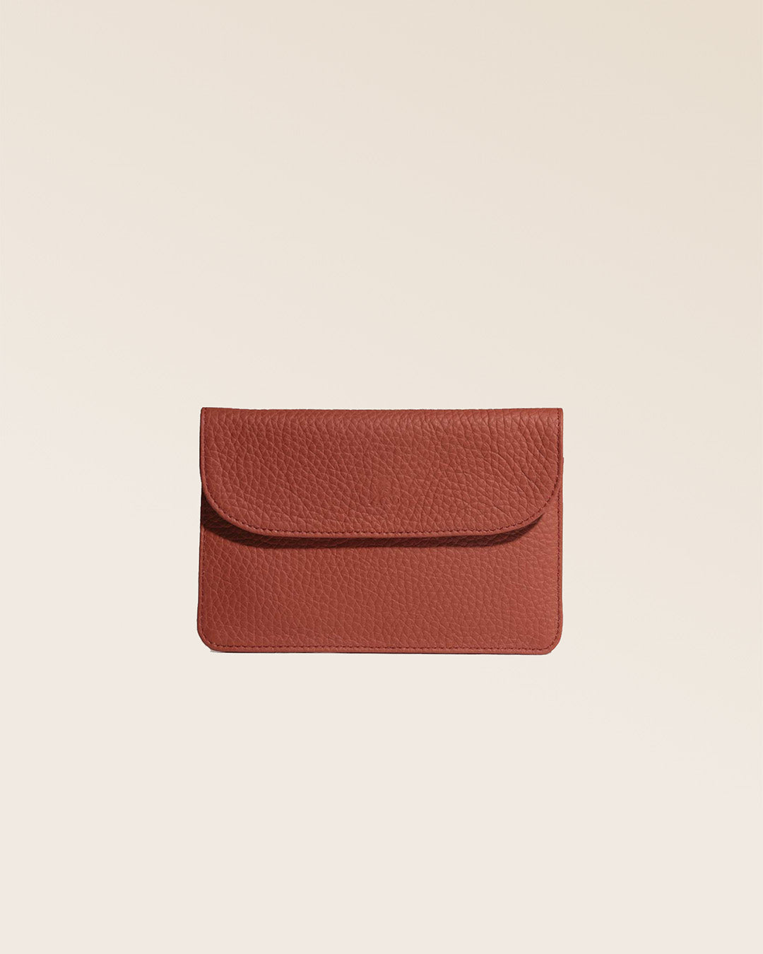 Notre porte-papiers Aurore en cuir façon vigogne terracotta vu de face fermé en studio.