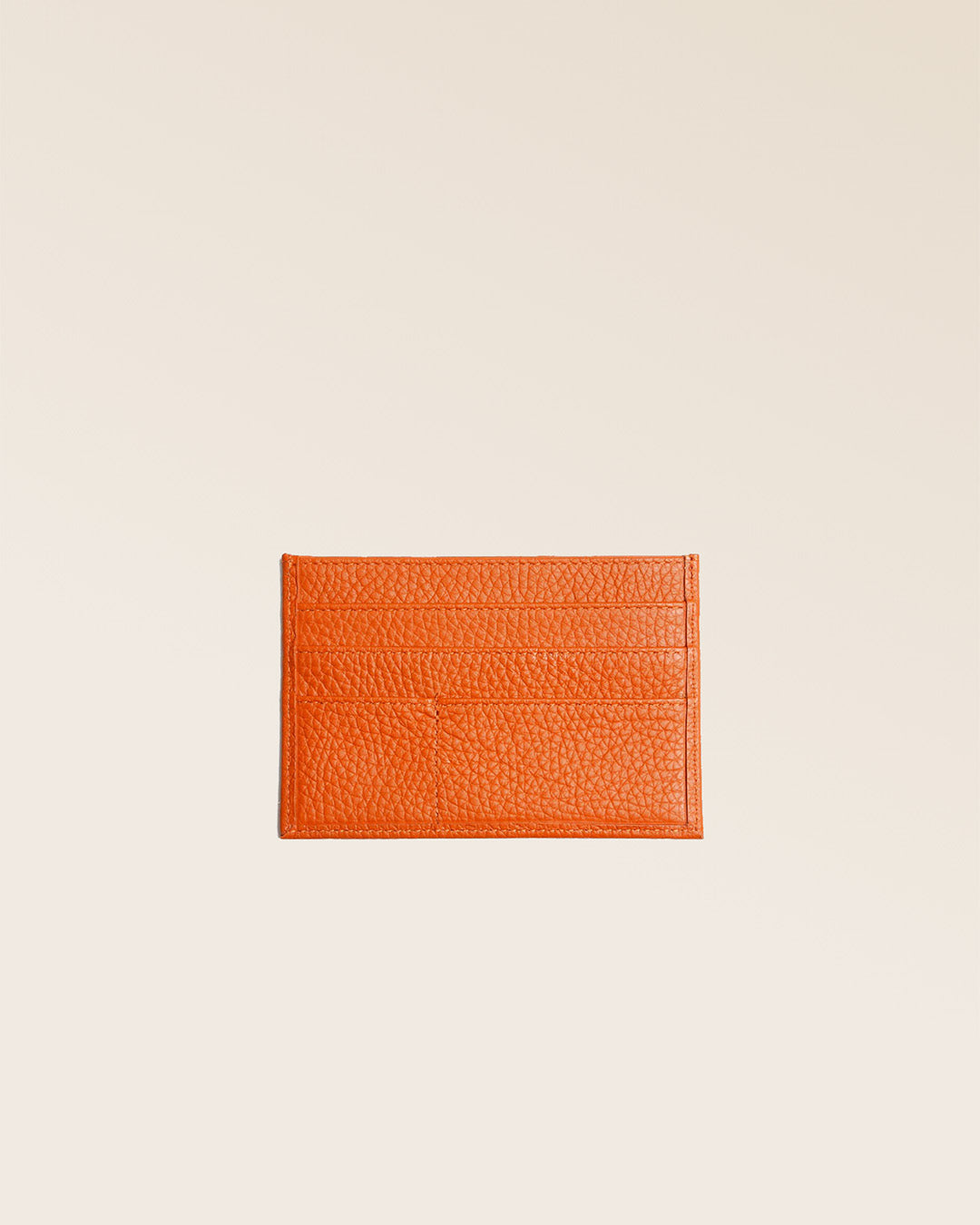 Notre porte-papiers en cuir façon vigogne orange vu de dos en studio.