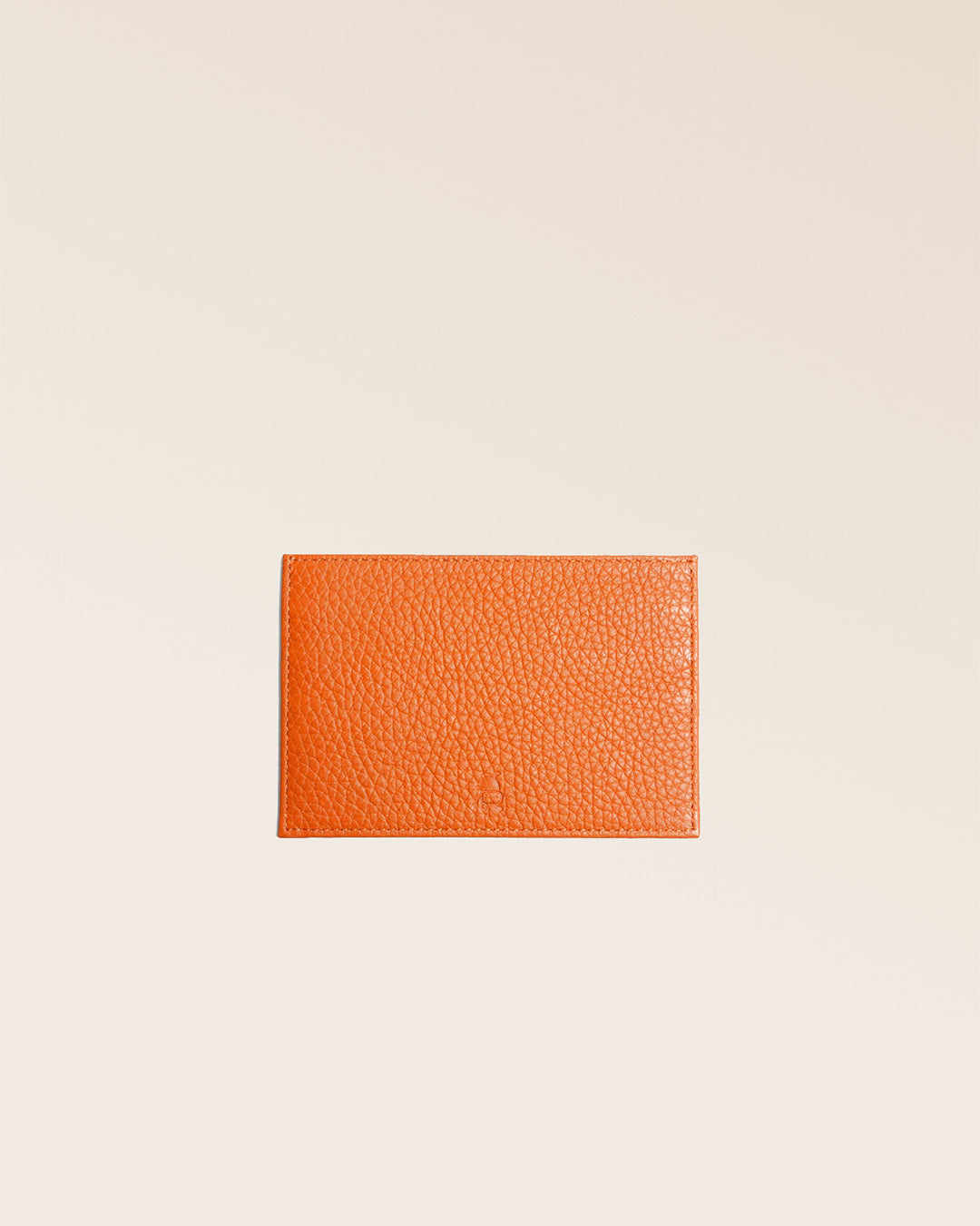 Notre porte-papiers en cuir façon vigogne orange vu de face en studio.