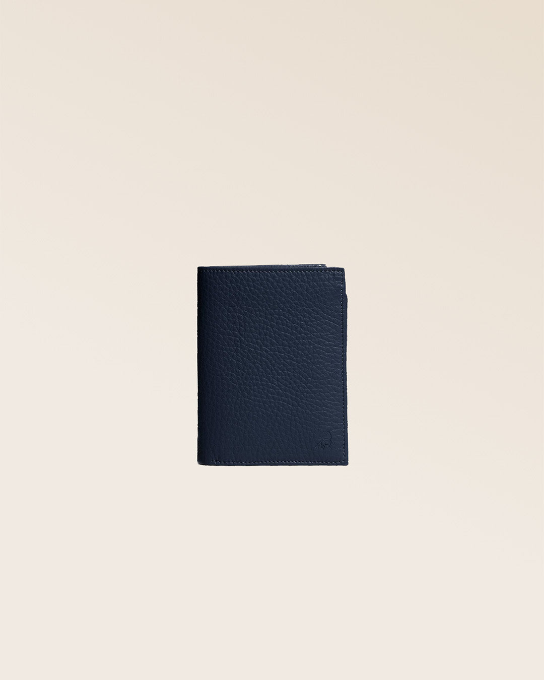 Notre portefeuile Malo en cuir façon vigogne bleu marine vu de face en studio.