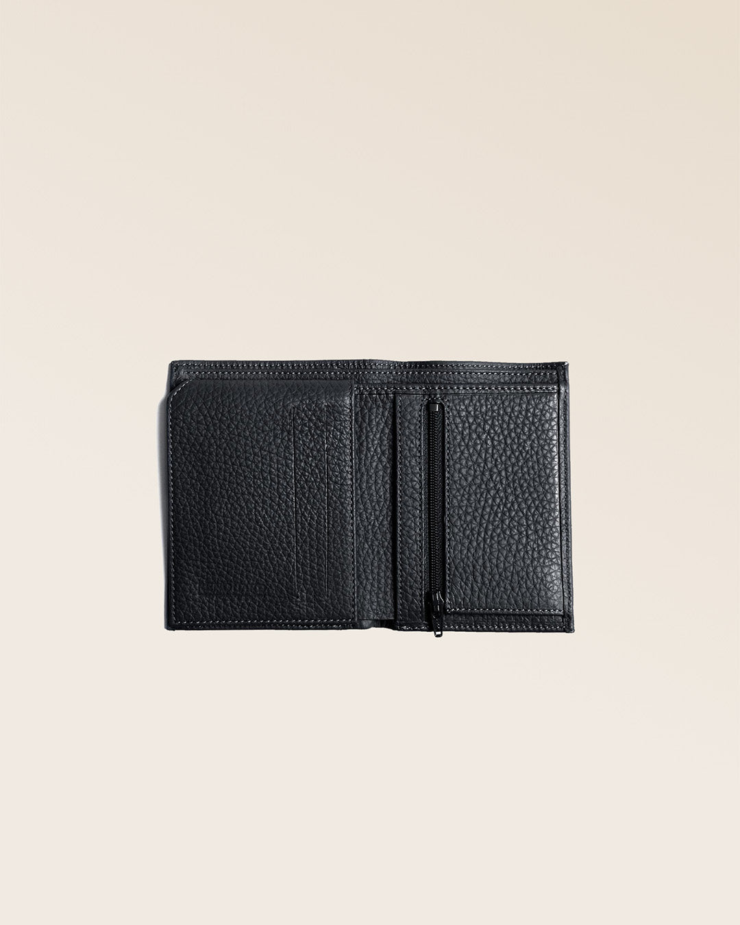 Notre portefeuille Malo en cuir façon vigogne noir vu ouvert partiellement en studio.