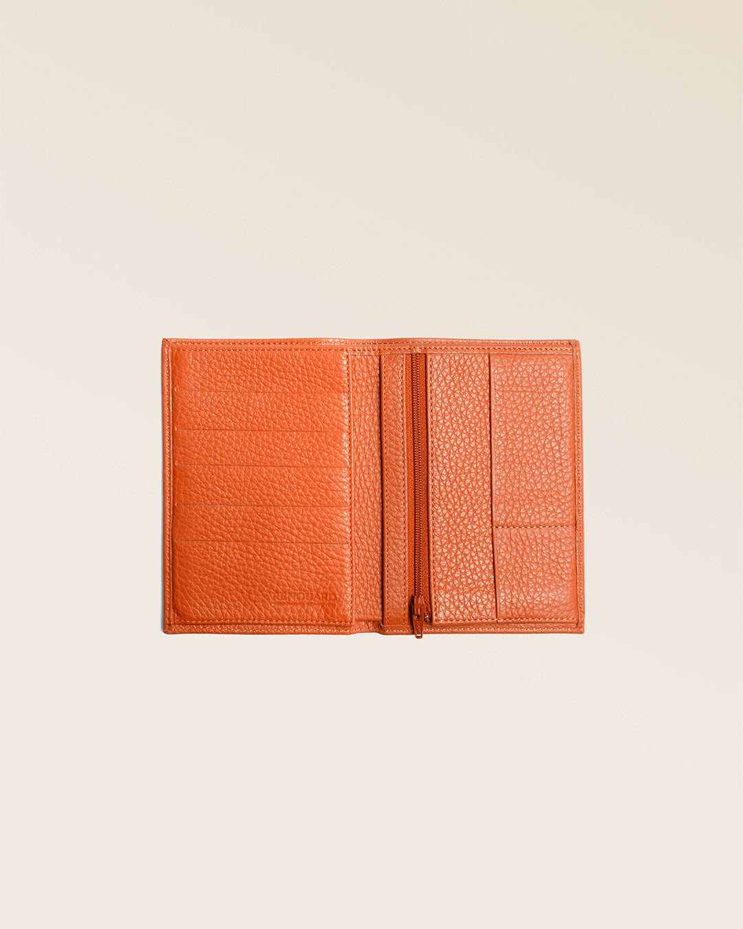 Our Papiers wallet in orange vicuña-style leather seen partially opened in the studio.