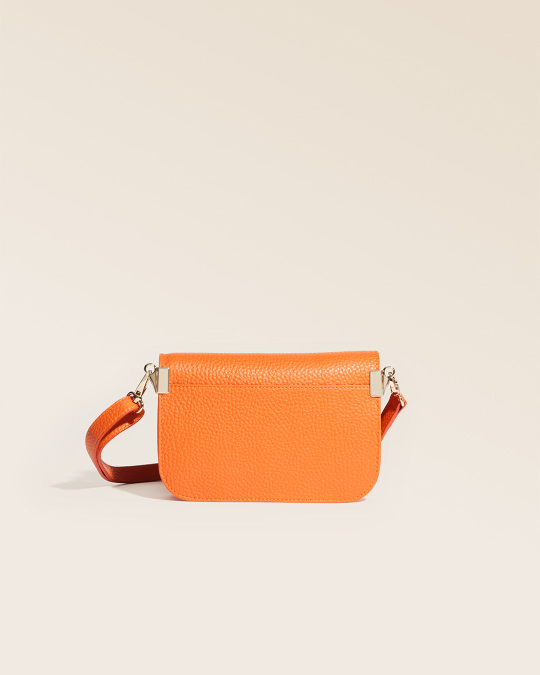 Notre pochette Coralie en cuir façon vigogne orange vue de dos en studio.