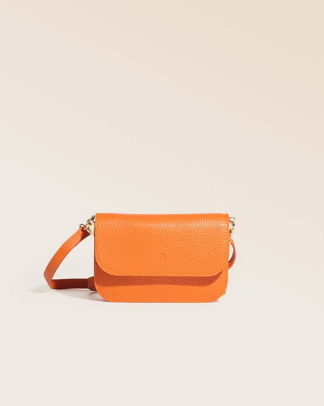 Notre pochette Coralie en cuir façon vigogne orange vue de face en studio.