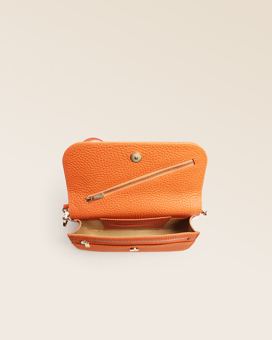 Notre pochette Coralie en cuir façon vigogne orange vue du dessus en studio.