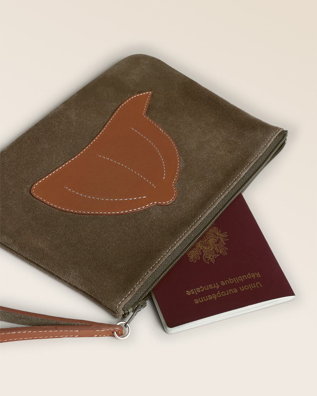 Notre pochette Galop Renouard en cuir veau velours truffe et vintage camel, vue de près en studio.