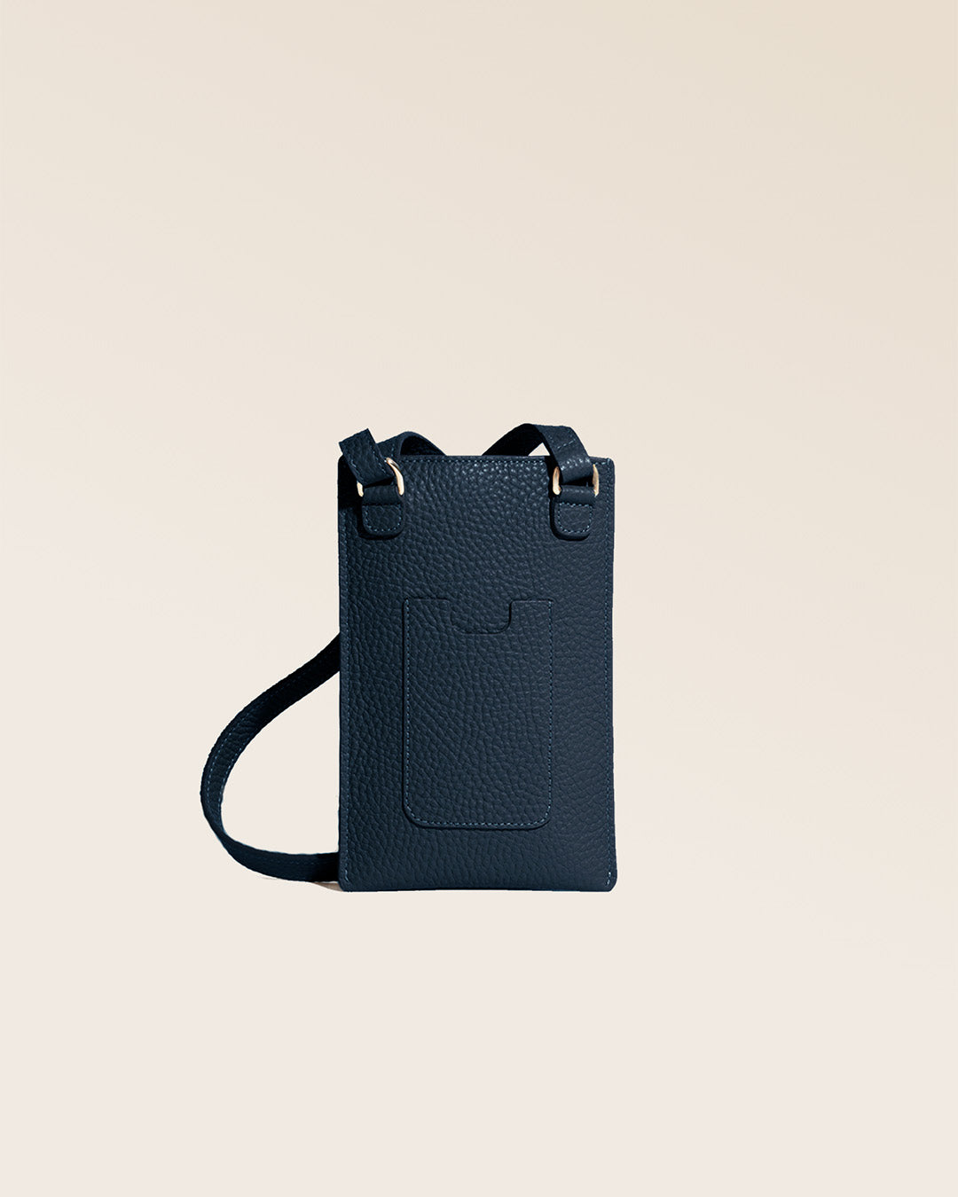 Notre pochette téléphone Renouard en cuir façon vigogne bleu marine vue de dos en studio.