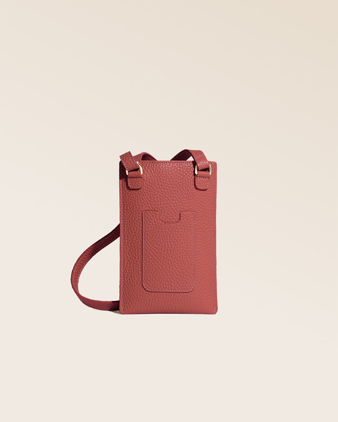 Notre pochette téléphone Renouard en cuir façon vigogne terracotta vue de dos en studio.