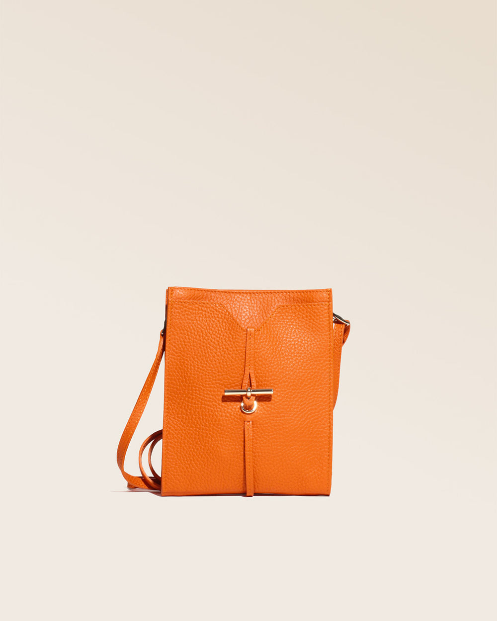 Notre pochette Aglaé Renouard en cuir façon vigogne orange, vue de face en studio.