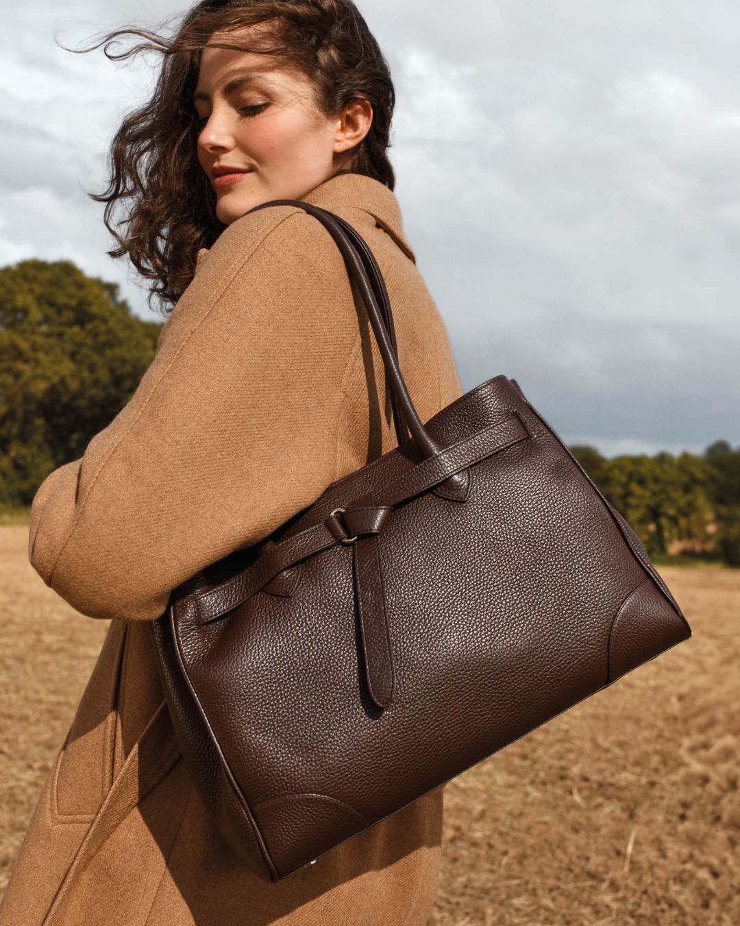 Notre sac Balneum en cuir façon vigogne chocolat vu porté par notre mannequin.