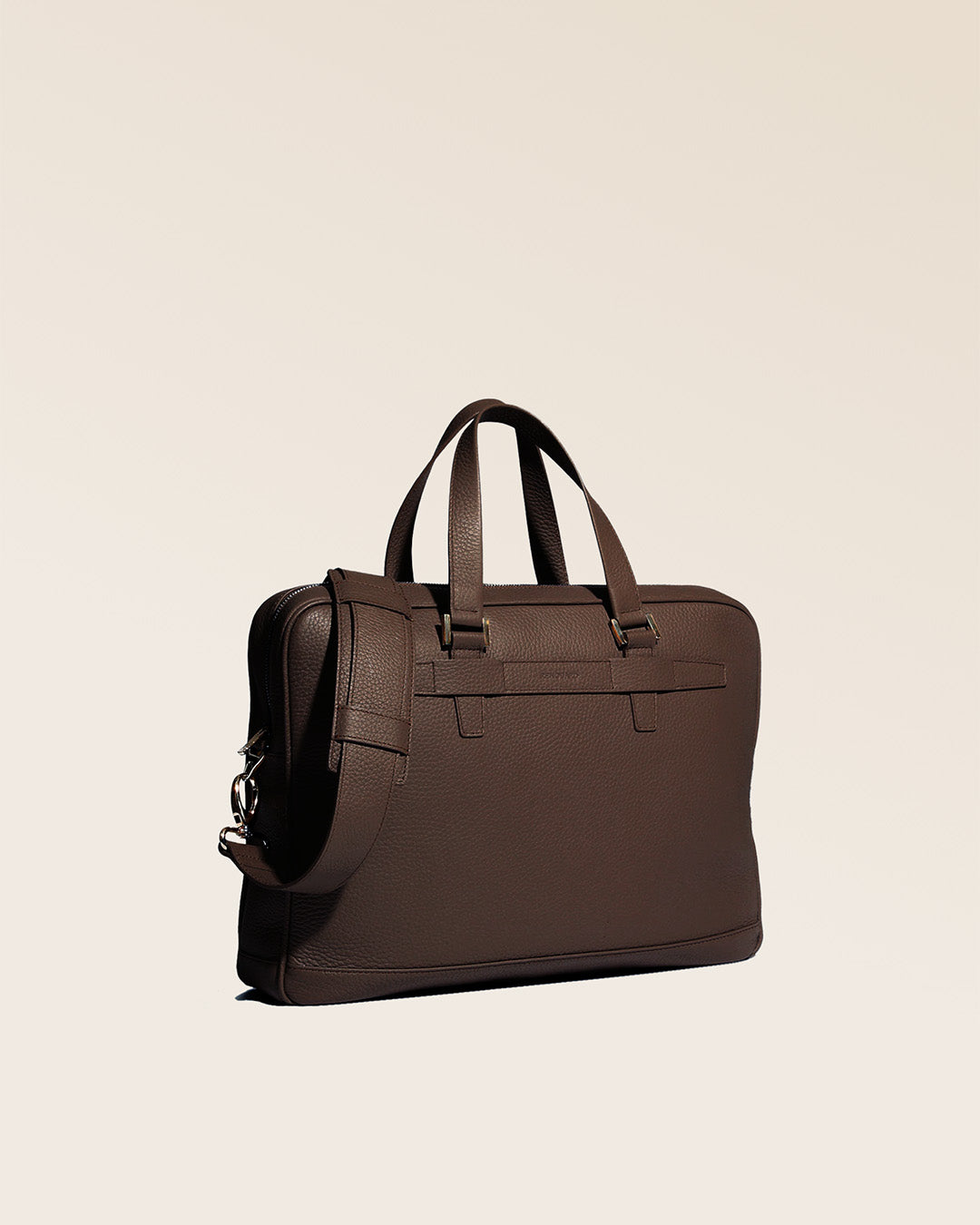 Notre sac Boston en cuir façon vigogne chocolat vu de quart en studio.