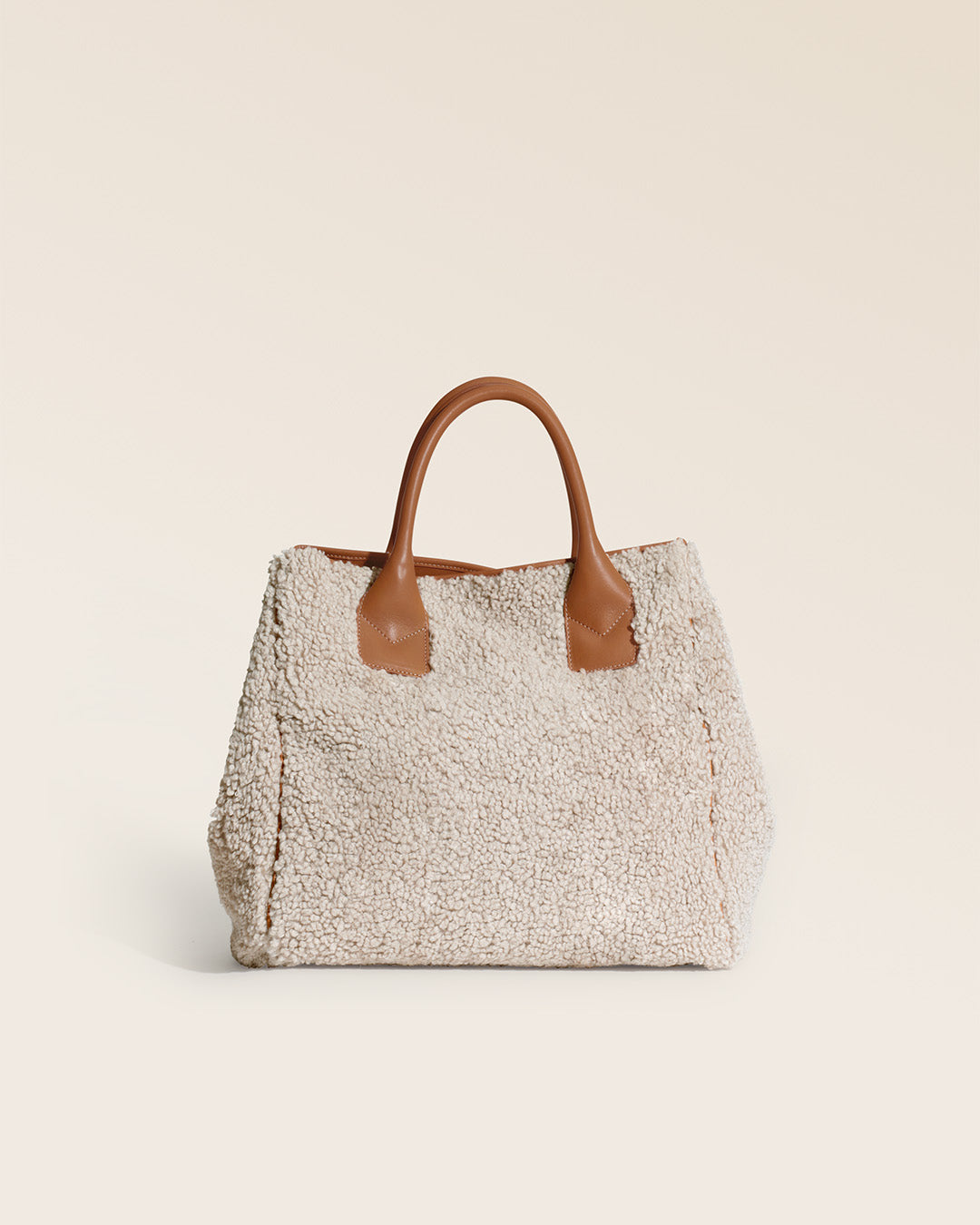 Notre cabas Max Renouard en toile bouclette naturelle et cuir vintage camel, vu de dos en studio.