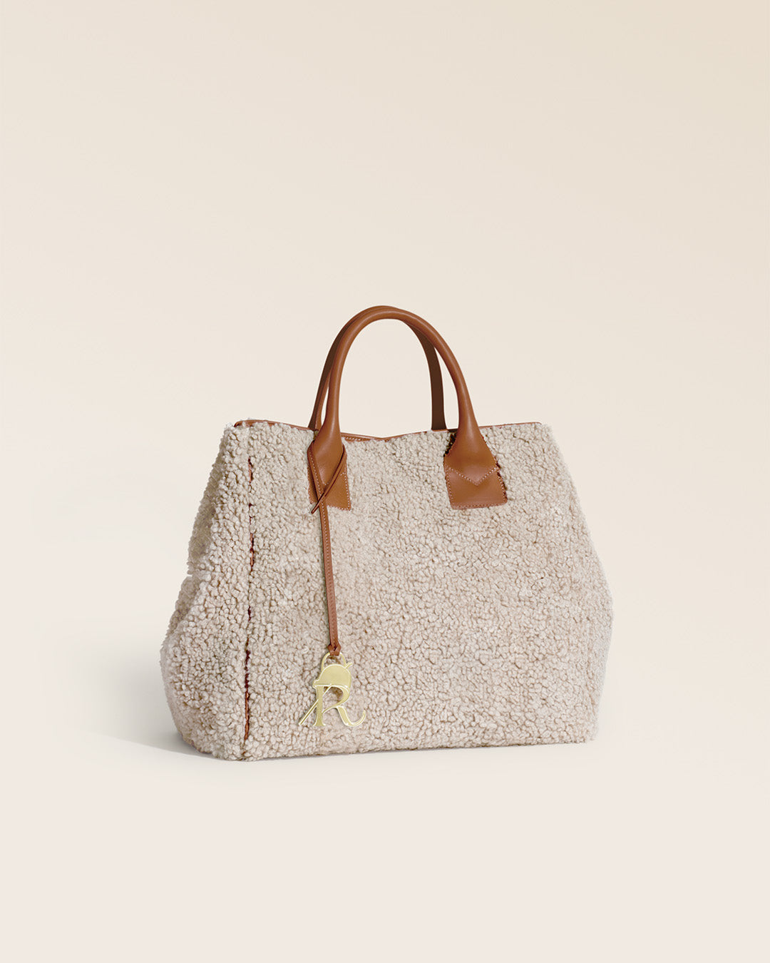 Notre cabas Max Renouard en toile bouclette naturelle et cuir vintage camel, vu de quart en studio.