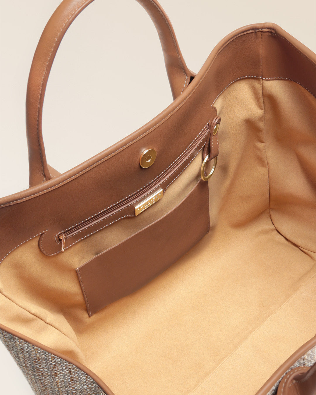 Notre sac cabas Max Renouard en toile tweed beige et cuir vintage camel, vu du dessus en studio.