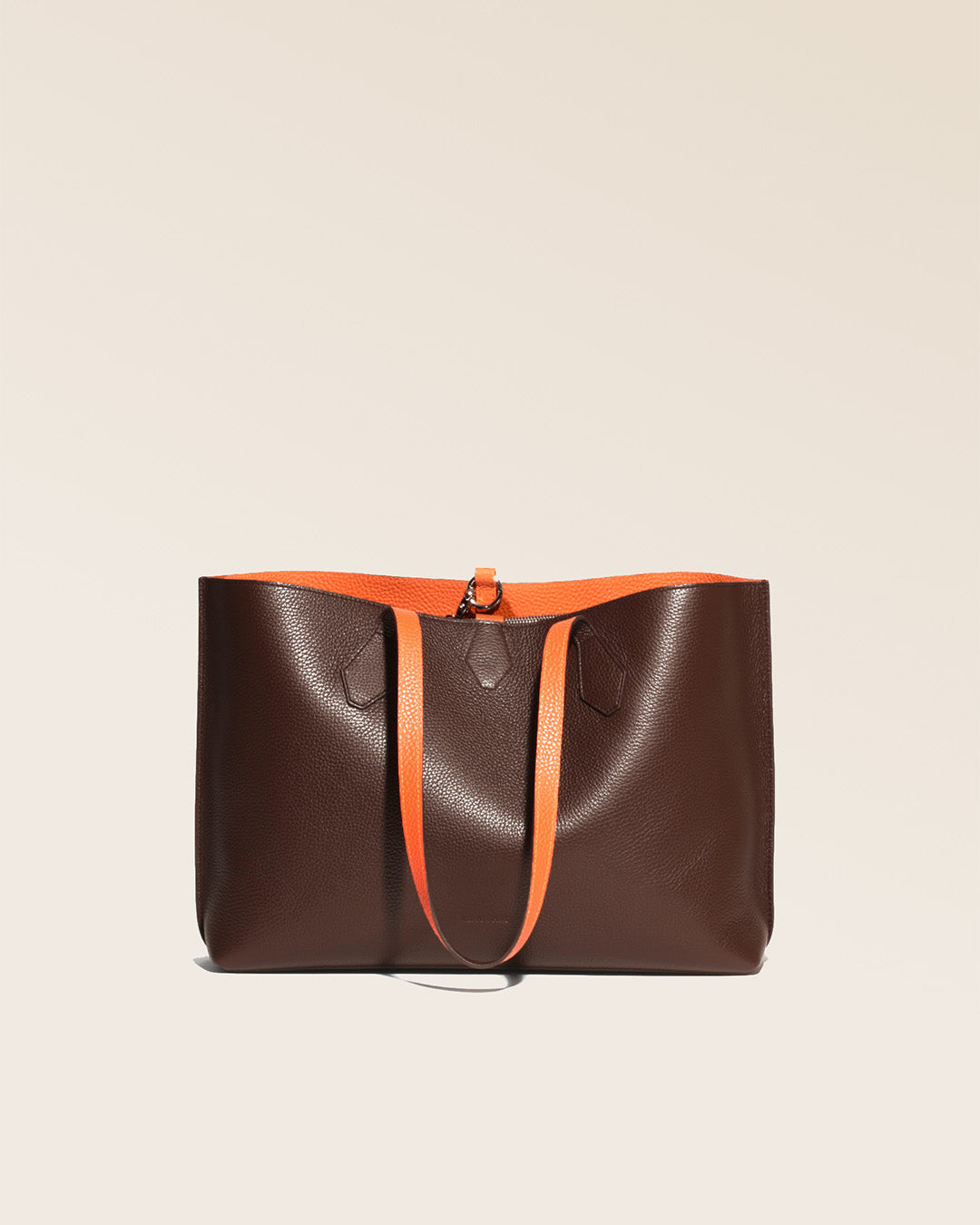 Our Shopper tote bag in chocolate and orange vicuña-style leather, seen from the front, handles relaxed.