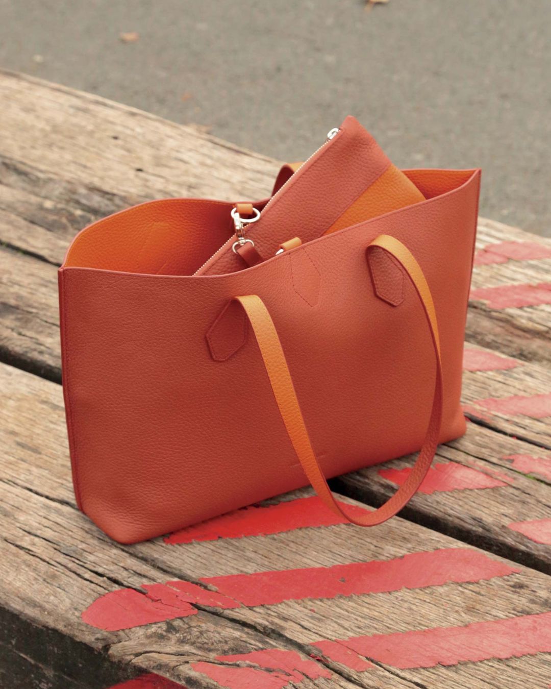 Notre sac cabas Shopper en cuir façon vigogne terracotta réversible cuir façon vigogne orange vu de quart en ambiance.