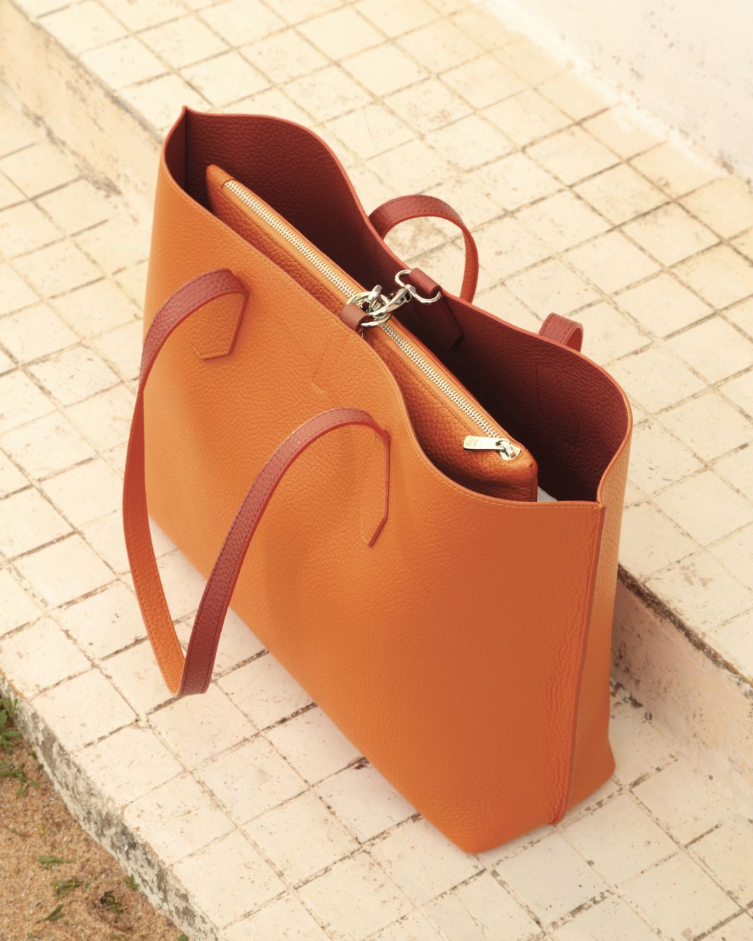 Notre sac cabas Shopper en cuir façon vigogne terracotta réversible cuir façon vigogne orange vu de quart en ambiance.