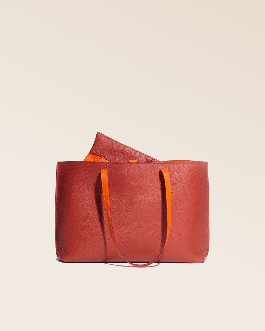 Notre sac cabas Shopper en cuir façon vigogne terracotta réversible cuir façon vigogne orange vu de face en studio.