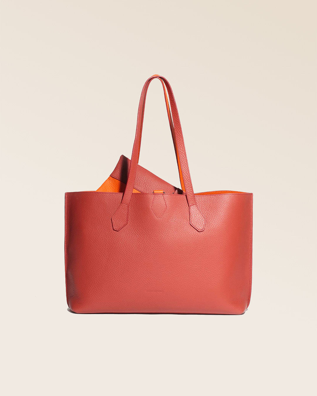 Notre sac cabas Shopper en cuir façon vigogne terracotta réversible cuir façon vigogne orange vu de face en studio.