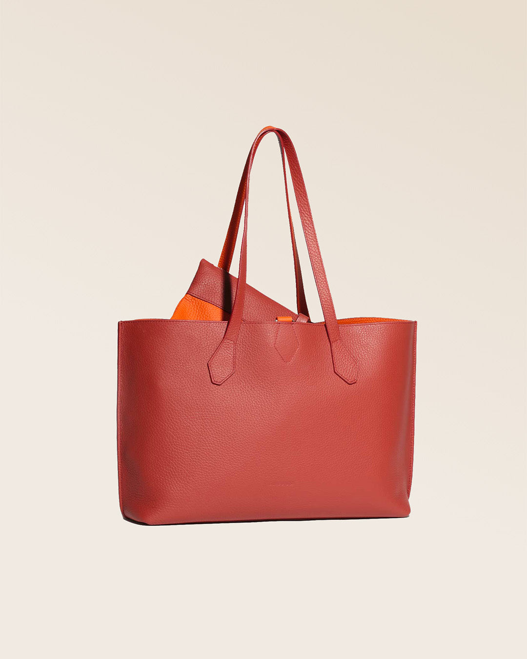 Notre sac cabas Shopper en cuir façon vigogne terracotta réversible cuir façon vigogne orange vu de quart en studio.